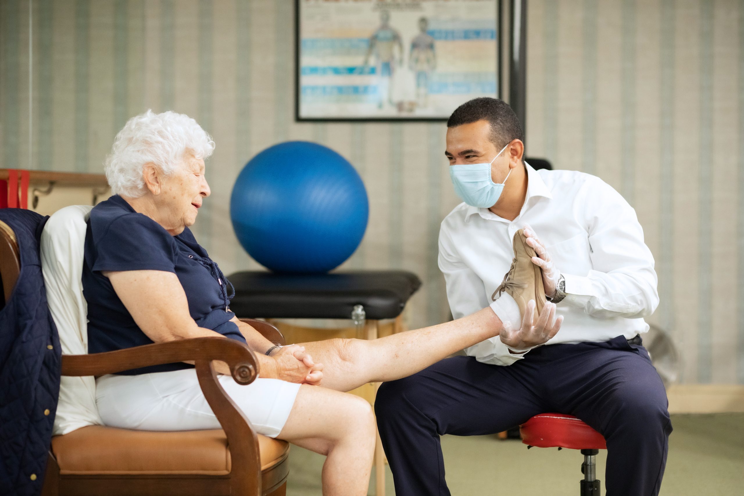 physical therapist helping elderly woman